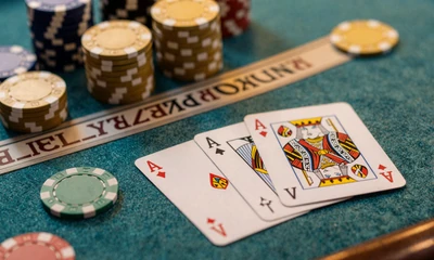 Blackjack-Karten mit Ass und K&ouml;nig auf t&uuml;rkisem Filz - Black Jack online im OnlySpins Live Casino