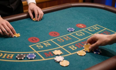 Baccarat-Tisch mit Player- und Banker-Feldern und goldenen Chips - Baccarat im OnlySpins Live Casino